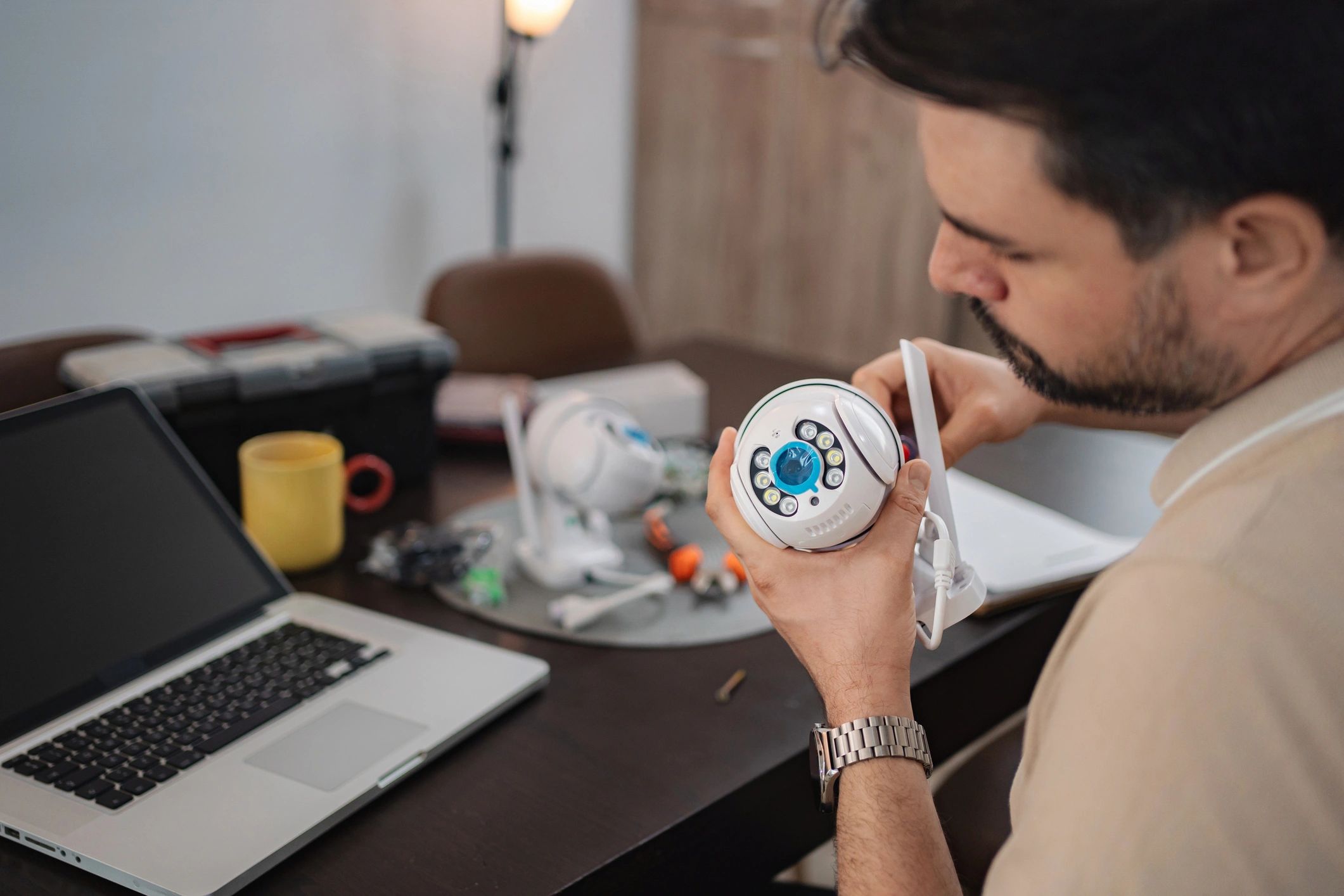 Technician installing surveillance camera at home using laptop